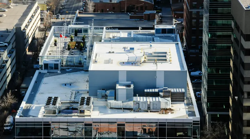 Aerial view of a commercial building's white flat roof with rooftop HVAC units